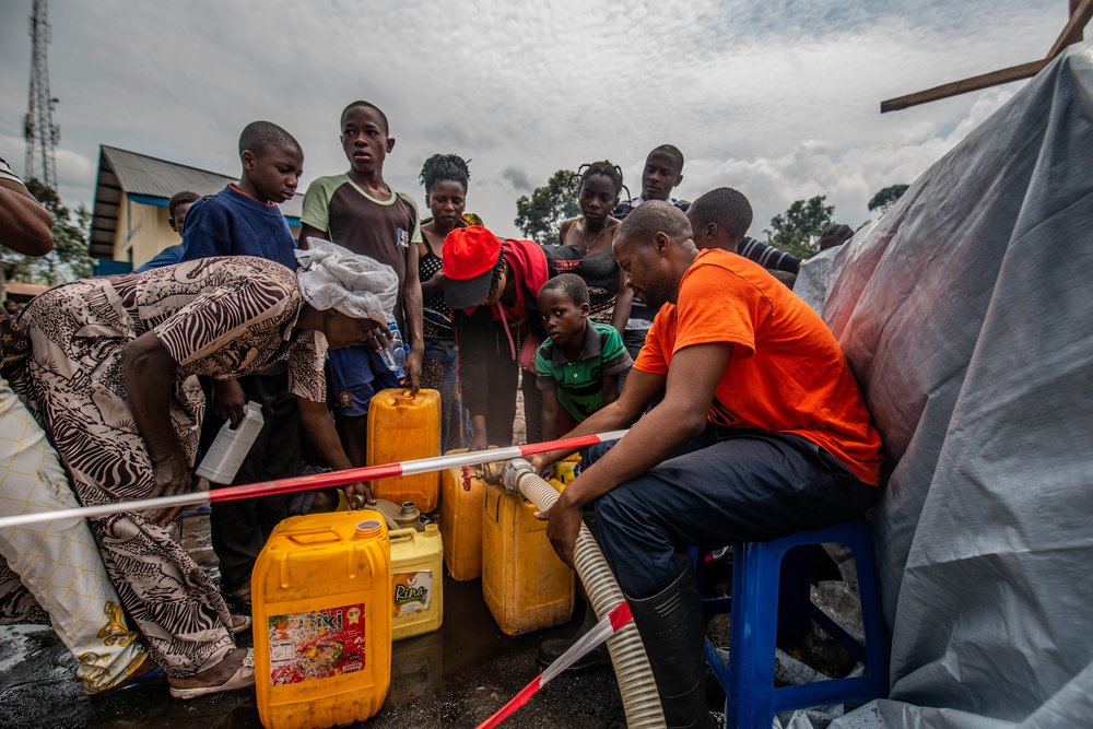 People have jerrycans filled with clean drinking water at an MSF distribution of water in Sake. North Kivu province, DRC, May 2021.