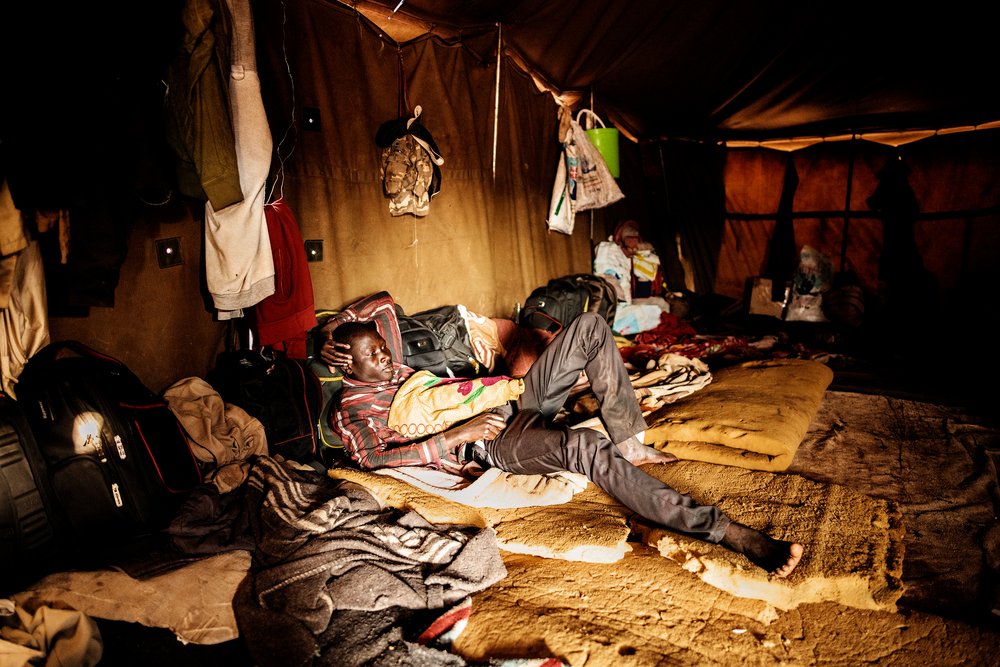 A migrant rests in a tent at a temporary shelter where migrants entering South Africa through Musina take refuge. © Luca Sola 2019