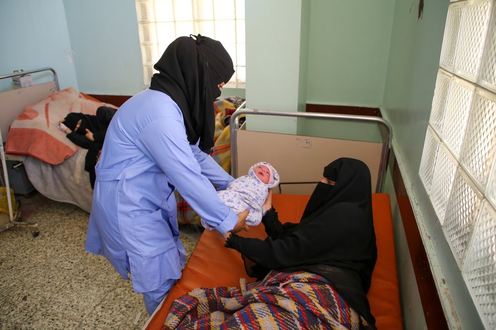 Midwife Maimona Yahya Faid Mohammad handing over the newborn baby to the mother Bushra at the inpatient department of the maternity unit supported by MSF at Al Jamhouri hospital in Taiz City, Yemen.