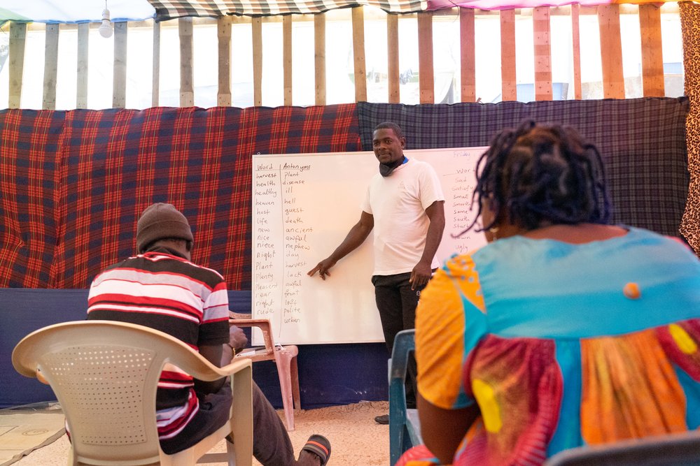 Bille Fergusson, while teaching English and French to other community members in their makeshift church in the area around Vathy centre. Bille is from the southern part of Cameroon. He came to Europe seeking safety, after his life was threatened.