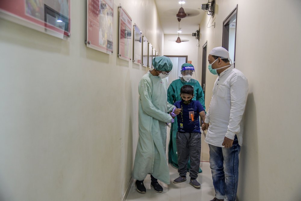 MSF Nurse accompanying nine years old XDRTB + EPTB male child to ECG Room at MSF independent Clinic, Mumbai- India