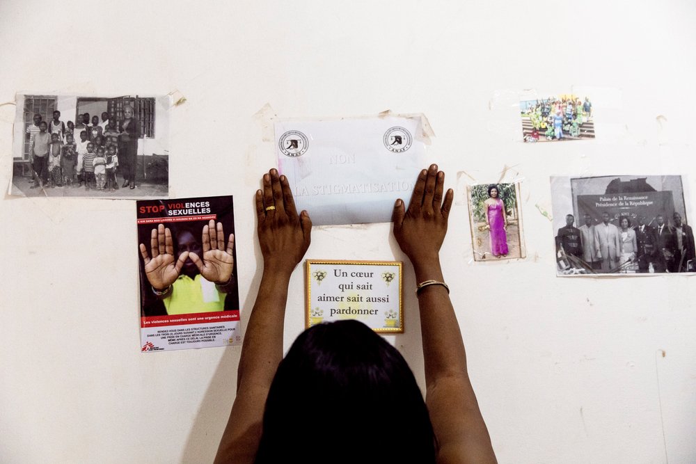 Nanette fixes a poster that says &quot;no to stigmatizsation&quot; in her office in Bangui, the Central African Republic, on December 11, 2020.