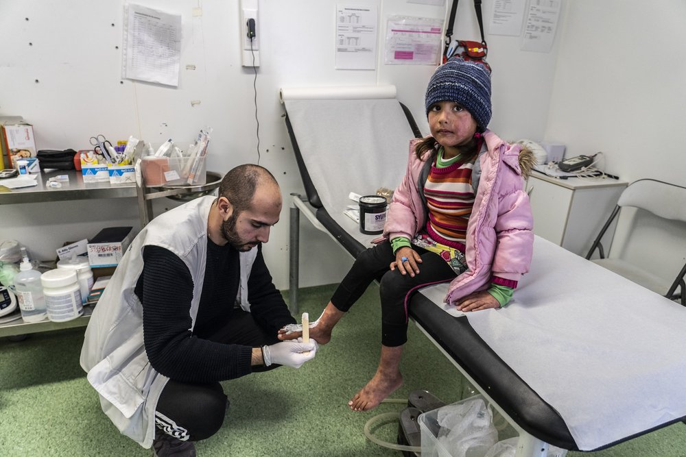 MSF nurse Theofilos, changes the bandage of the 6 year old Behnaz from Afghanistan. She got burned from boiling water while living in the camp of Moria.