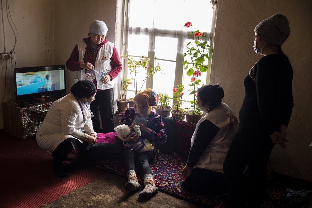 An MSF paediatrician and a health promoter, plus a Ministry of Health nurse, visit a new mother and her eight-day-old baby in a home-based post-natal consultation