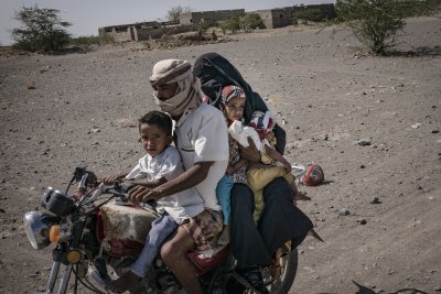 A family travelling together through the Mawza area of Yemen - the red stones indicated the presence of mines © Guillaume Binet/MYOP