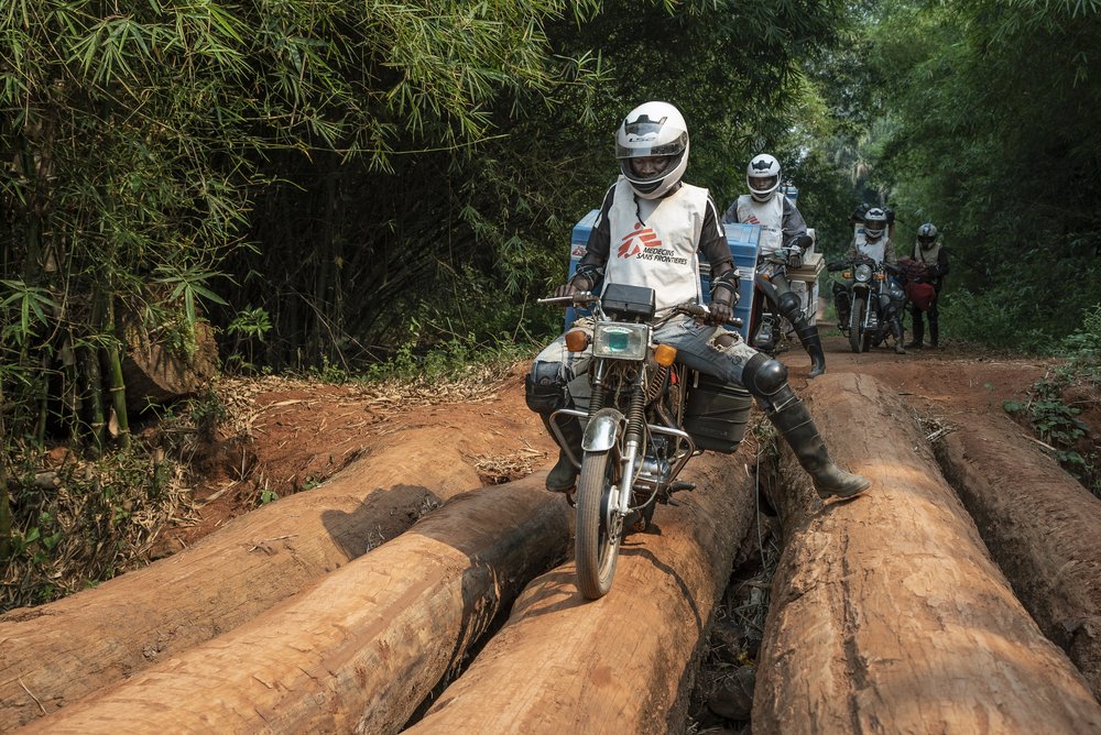 Members of an MSF emergency team transport measles vaccines by motorbike to Boso Manzi, Mongala province. Democratic Republic of Congo, February 2020. 