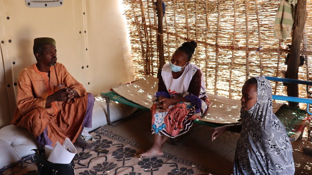 An MSF health promoter talks with displaced people in a settlement in Dori, in the Sahel region of Burkina Faso.