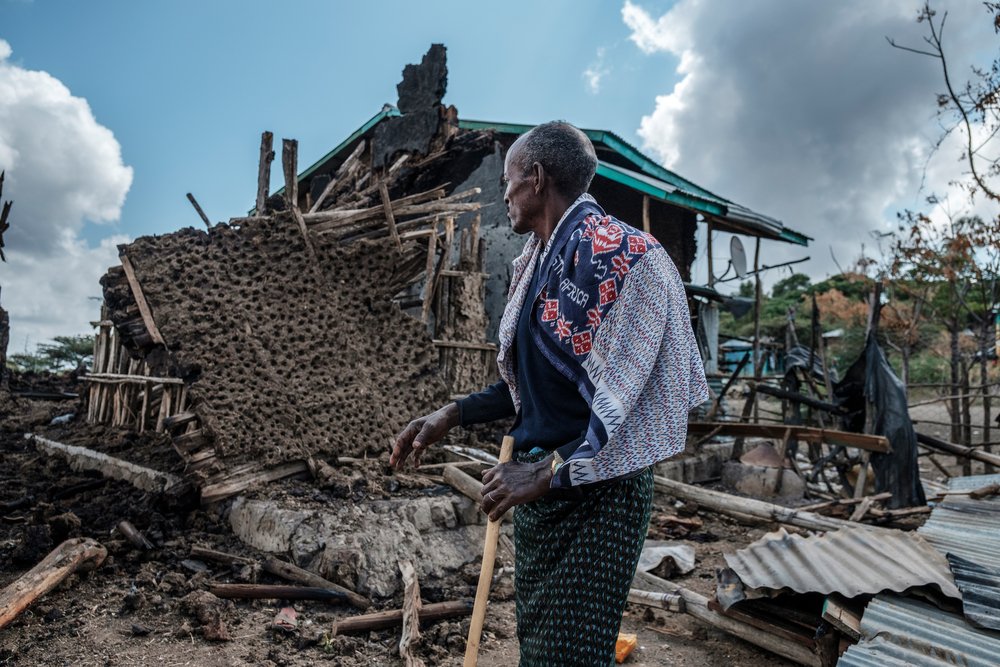 A man stands in front of his destroyed house in the village of Bisober, Ethiopia, on December 9, 2020.