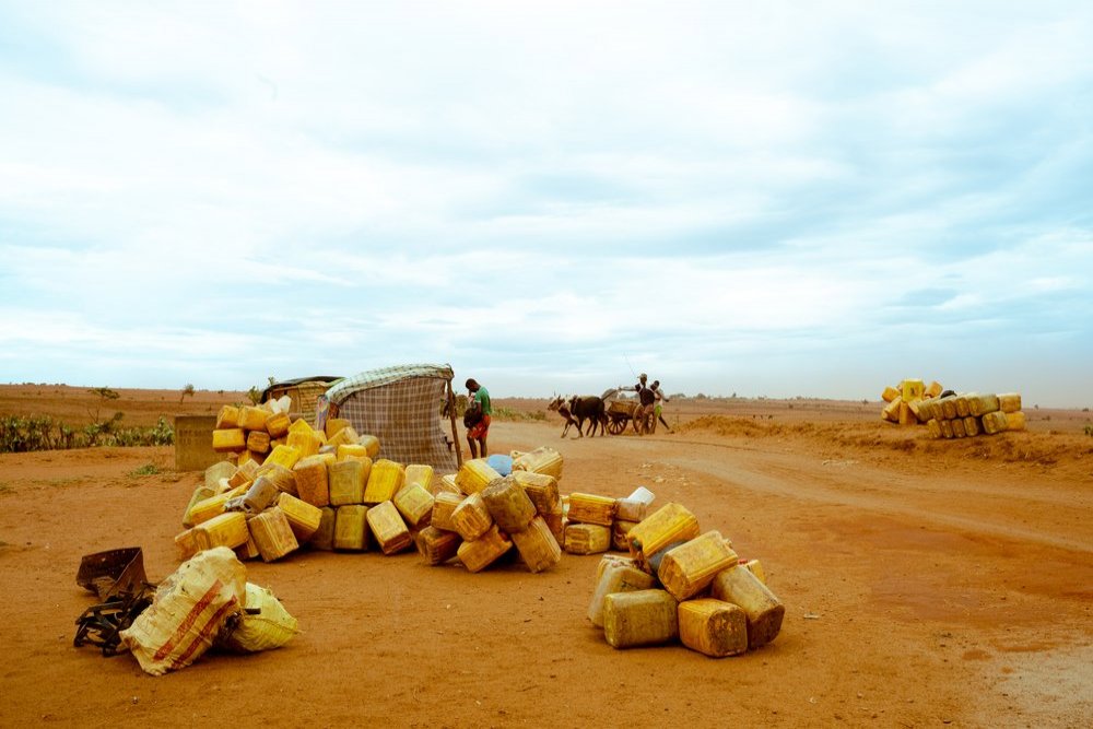 At a crossroads on the national road, empty jerrycans await the arrival of a tanker truck to provide water for the families in the area.