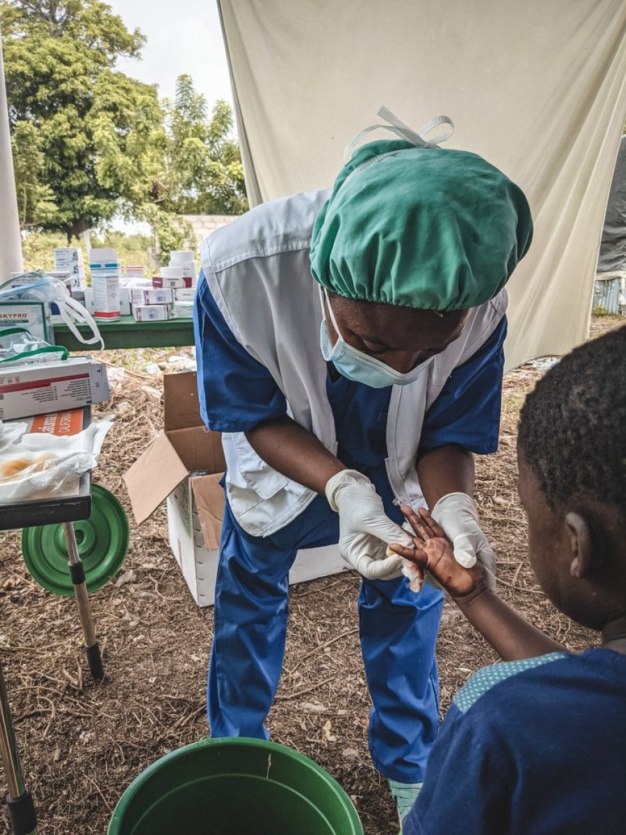An MSF nurse examines a boy&#039;s cut finger. An MSF mobile clinic provides primary and mental health care services to people staying at an informal IDP camp in Les Cayes called Papa Numa.
