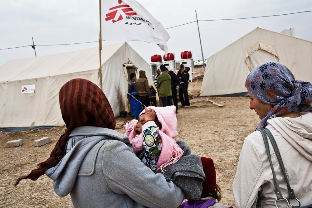 A Syrian refugee carries her child to the MSF medical clinic at the Domeez camp in northwest Iraqi Kurdistan, January 25, 2013. 