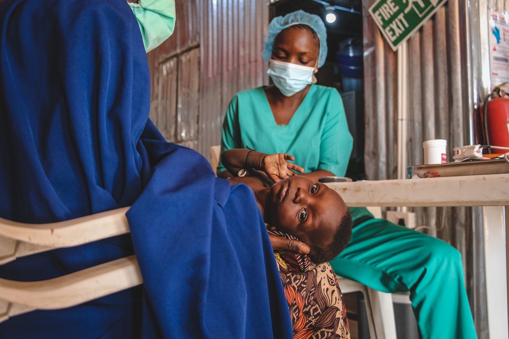 An MSF nurse examining a child at Nilefa Kiji nutrition hospital run by MSF in Maiduguri, Borno State in Nigeria. (June, 2022).