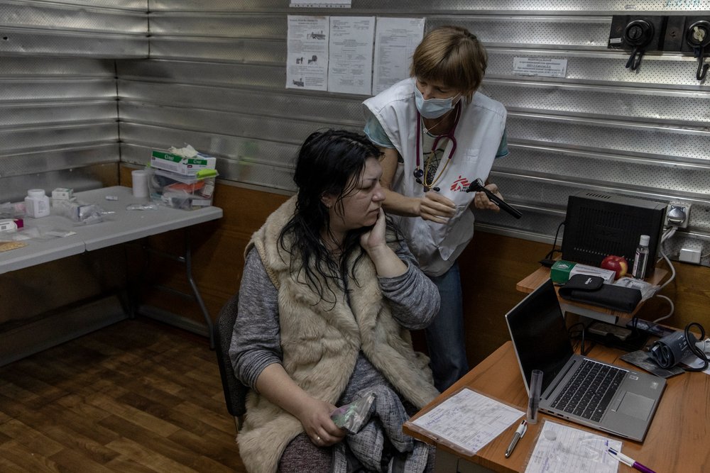 Elena, 35-years-old is examined by MSF doctor Kelly, for an ear infection that hurts her throat, in Kharkiv, Ukraine. (April, 2022).
