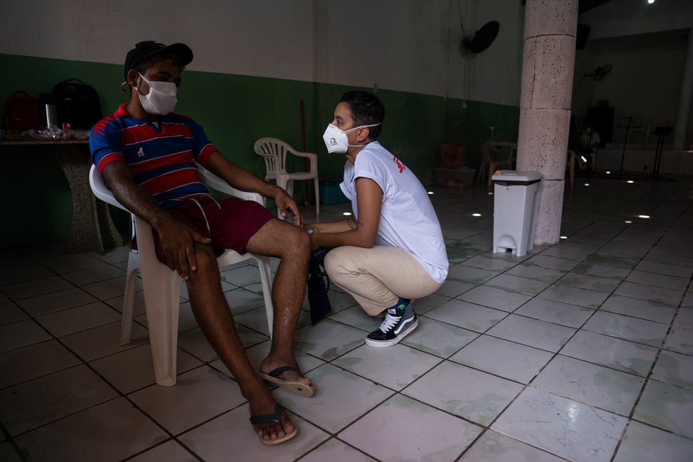 Jaqueline Serena Boschini, MSF nurse, talks to a patient in a mobile clinic in the Grande Bom Jardim territory in Fortaleza.
