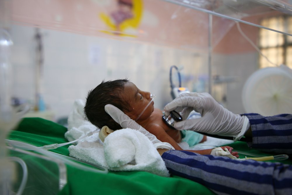 A doctor examining a baby admitted to the special care bay unit for respiratory distress at Al-Jamhouri hospital supported by MSF in Taiz City, Yemen.