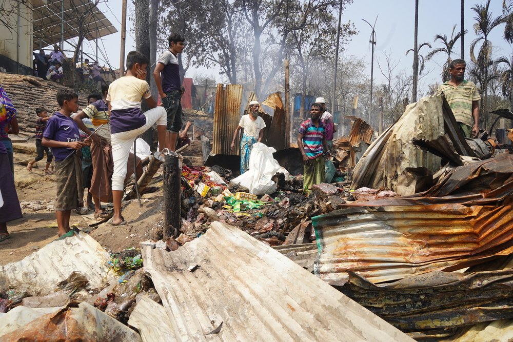 The morning after the fire destroyed thousands of shelters and facilities, people like these men were trying to save what was left of their belongings.