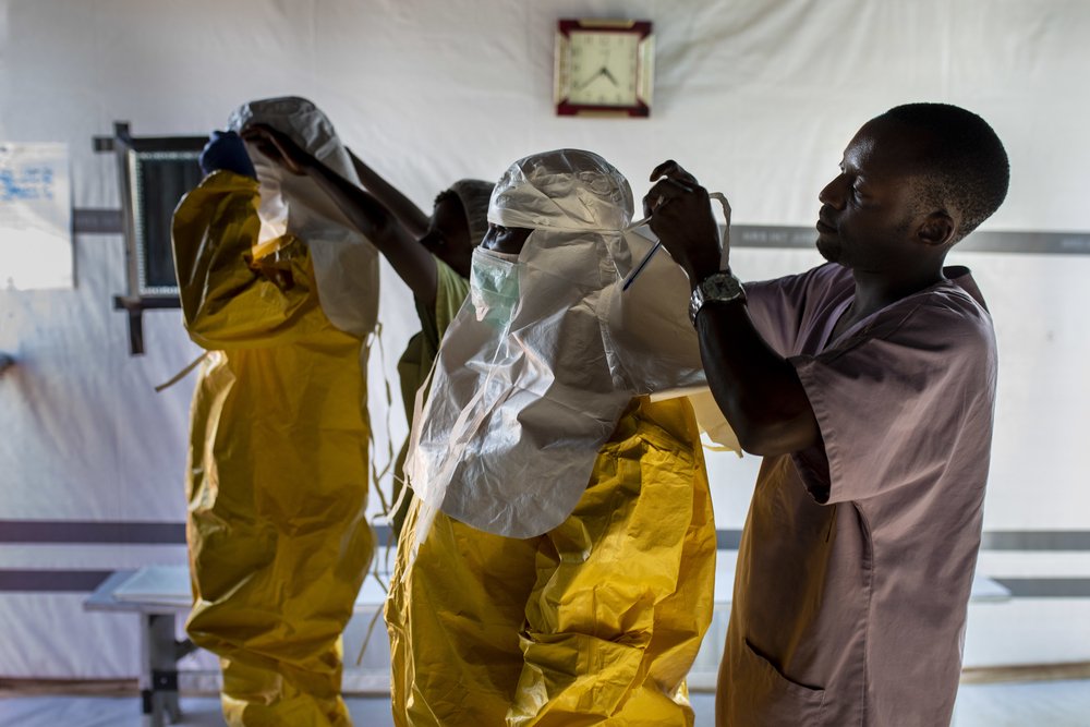 Medical and hygienist staff get dressed with the PPE to get into the high risk zone of the Ebola Transit Center 