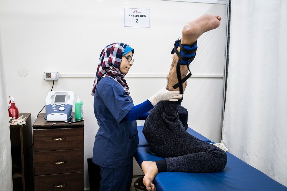 Sabrine Wadi, a physiotherapist working  with MSF at Al-Awda hospital in northern  Gaza, assists a patient with his exercises.  Palestine, November 2019.