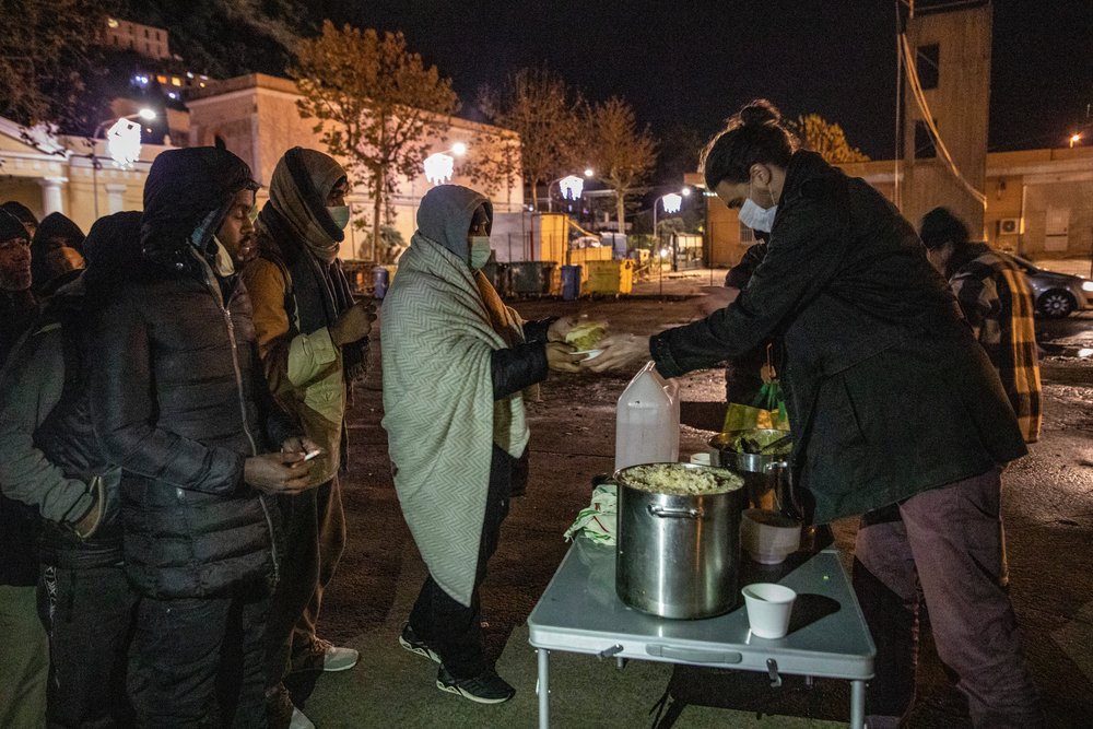 Every evening volunteers can be found in a parking lot in front of the cemetery, distributing hot meals and clothes to people on the move in Ventimiglia.
