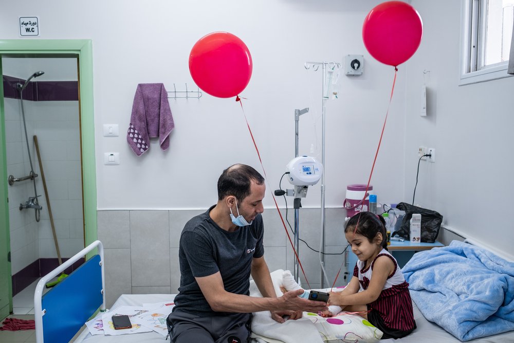Four-year-old Hala laughs as she speaks to her mother and sisters, a day after surgeons with the MSF limb reconstruction unit at Al-Awda hospital operated on her foot. 