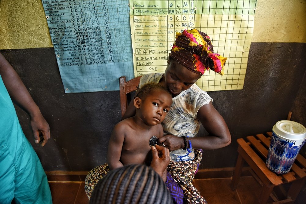 26-year-old Ka Musa holds her child, who has been diagnosed with malaria, during a consultation with Ministry of health staff at the MSF-supported Hangha community health centre in Kenema, Sierra Leone.
