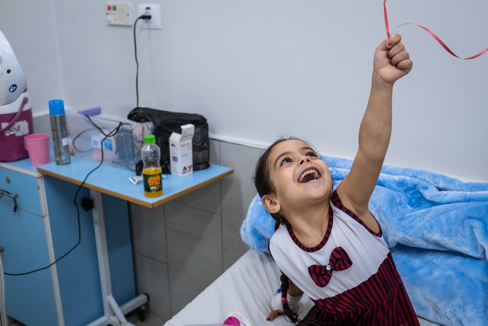 Four-year-old Hala plays with a balloon a day after surgeons with the MSF limb reconstruction unit at Al-Awda hospital operated on her foot.
