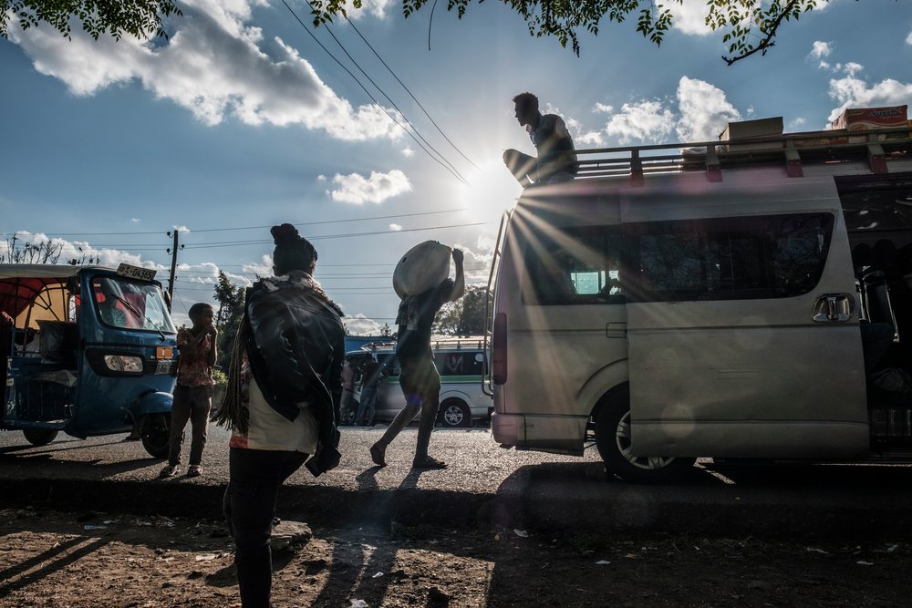People stand next to a public transportation van in Alamata, Ethiopia, on December 8, 2020.