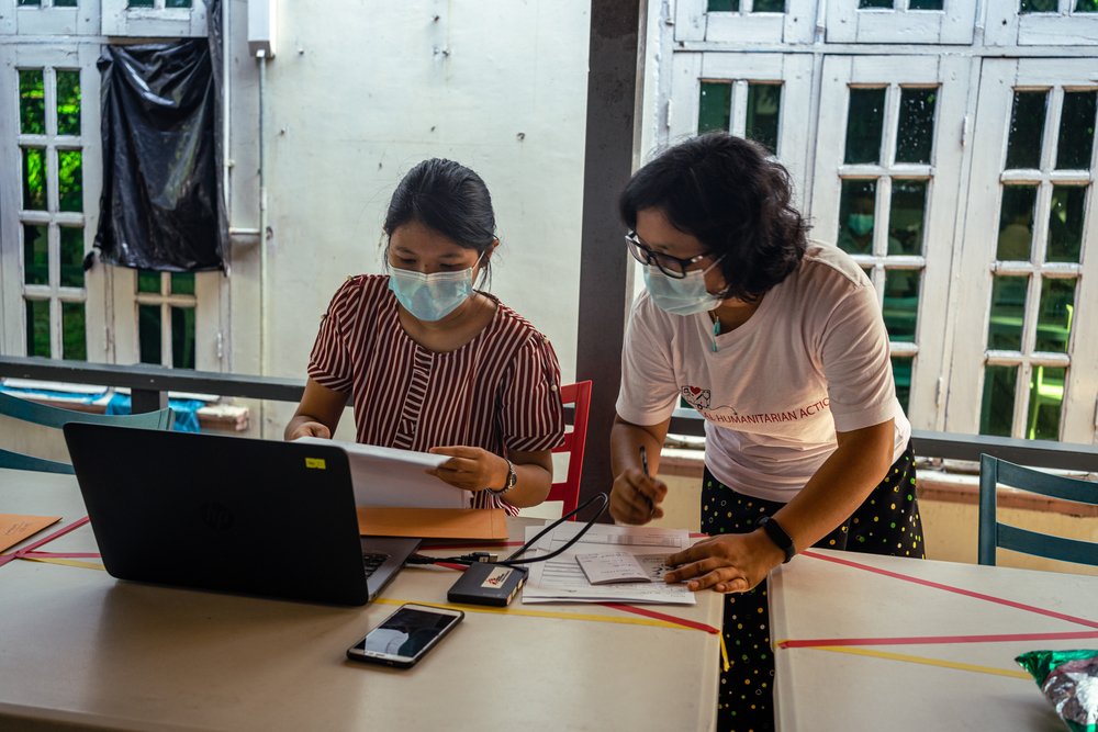 Two MSF staff members prepare for a consultation with an HIV/hepatitis C co-infected patient.