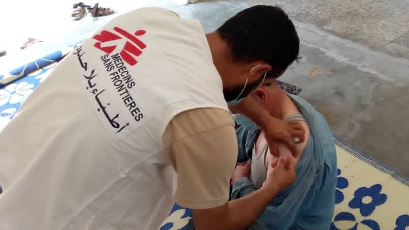 MSF staff vaccinating a displaced man in a camp in northwest Syria. (August, 2022).