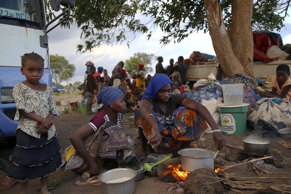 A woman cooks over an open fire, on the outskirts of Mueda, in the northern Mozambican province of Cabo Delgado. (December, 2021).