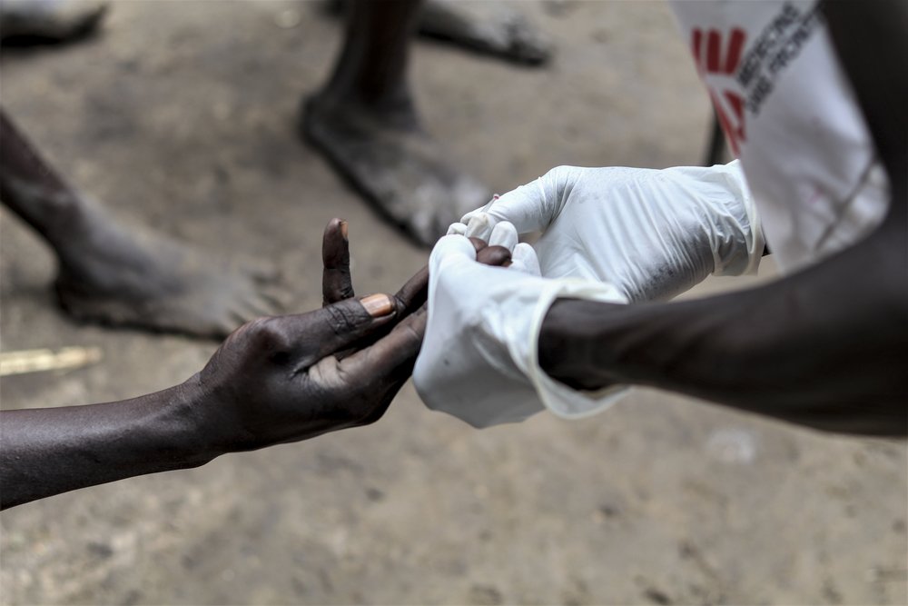 An MSF staff administers a rapid testing for malaria in Lukurunyarg.