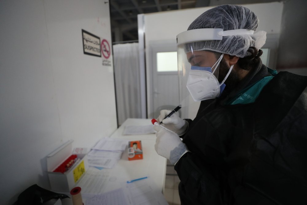 MSF nurse filling in the patient’s data on a UTM after taking her sample for the PCR test. 