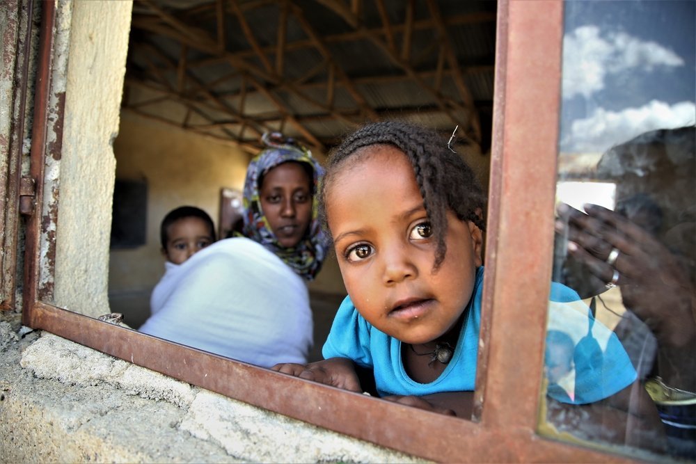 A displaced woman and her children stand at Abdimalaha school, Adwa, a town in central Tigray.