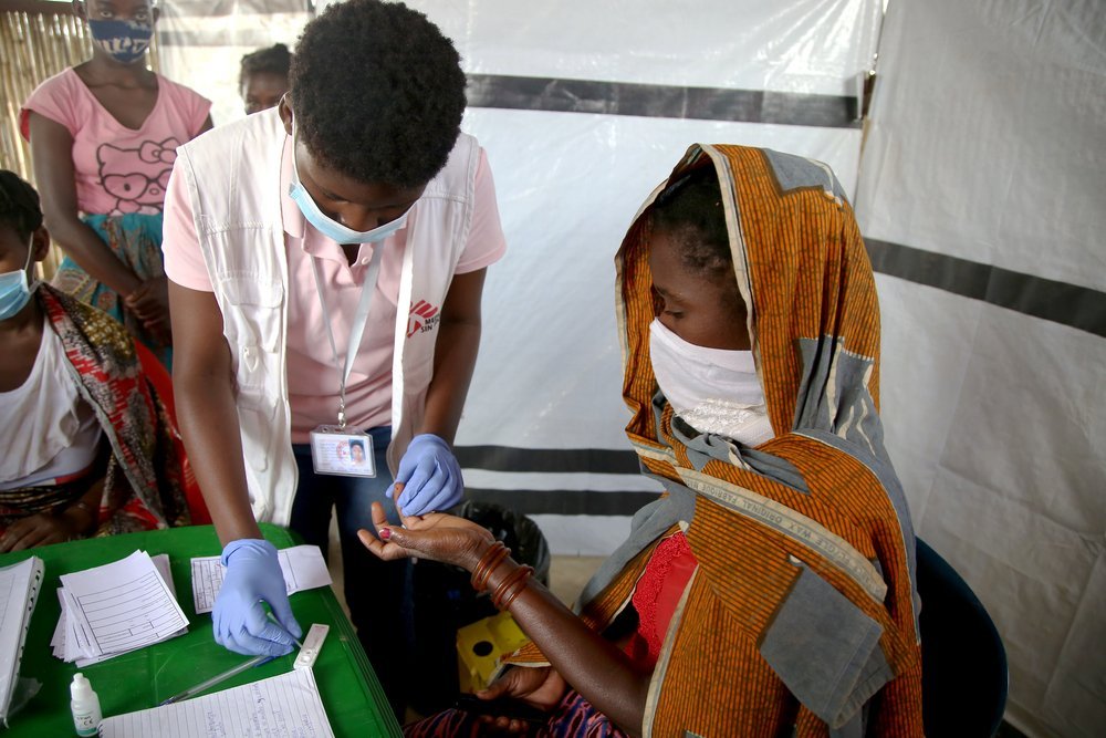 A nurse administers a malaria test for a woman at an MSF health post in Eduardo Mondlane. (December, 2021).