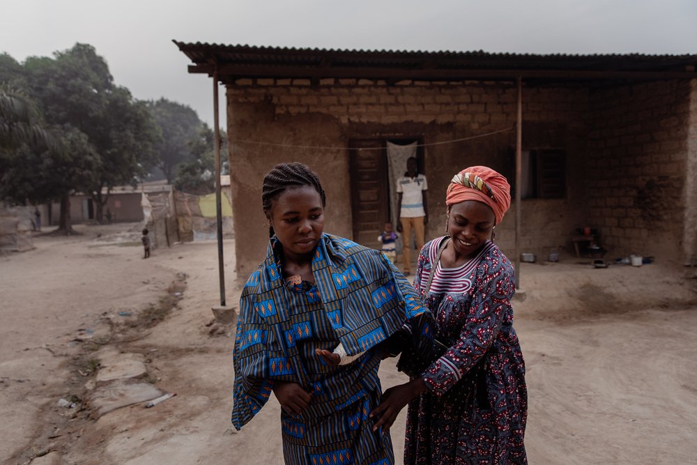 Claire, France&#039;s sister, helps her dress up in front of her house, for her first external consultation at the MSF’s SICA hospital, on 25 January 2021. She completed her inpatient treatment and left the hospital the day before. 