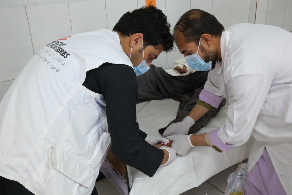 MSF Emergency room supervisor Masood Khan treats a patient for a gunshot wound at the Boost hospital. Helmand province, Afghanistan