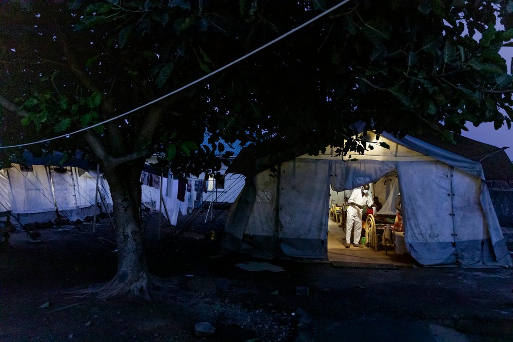 A member of MSF medical staff attends to a patient at night in MSF malaria tent in Aweil State Hospital, South Sudan, October 27th, 2021.