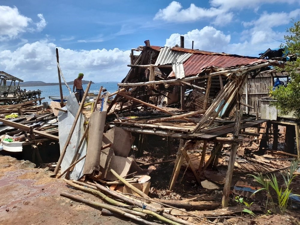 Brgy. Geotina, Basilisa, Dinagat Islands: A man looks through the debris to see what he can use to rebuild his home. (January, 2022).